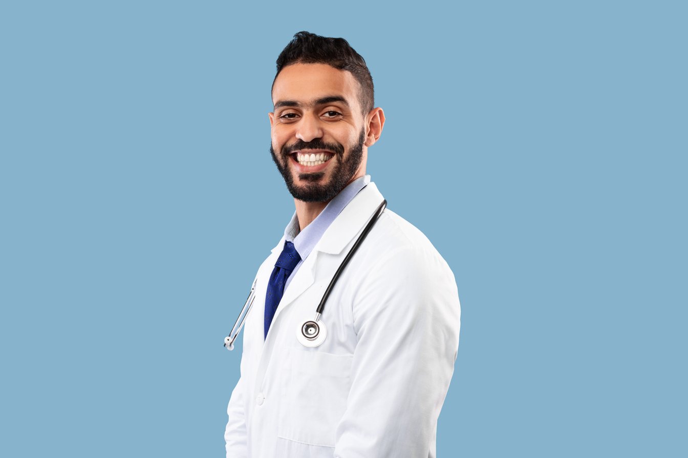 Headshot of Arab Doctor Guy Wearing Uniform Posing in Studio